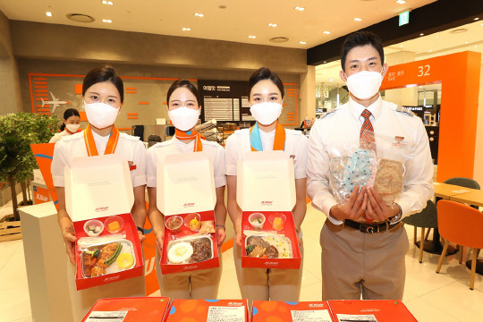 제주항공 부산지역 승무원들이 추석을 맞아 서울 여행맛 3호점에서 부산지역 아동센터와 복지관 청소년들에게 전달할 기내식과 어르신들에게 전달하기 위해 직접 만든 면 마스크를 들어보이고 있다. <제주항공 제공>